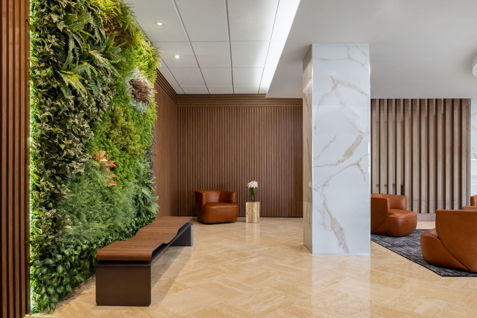 A lobby with a bench and a wall of plants.