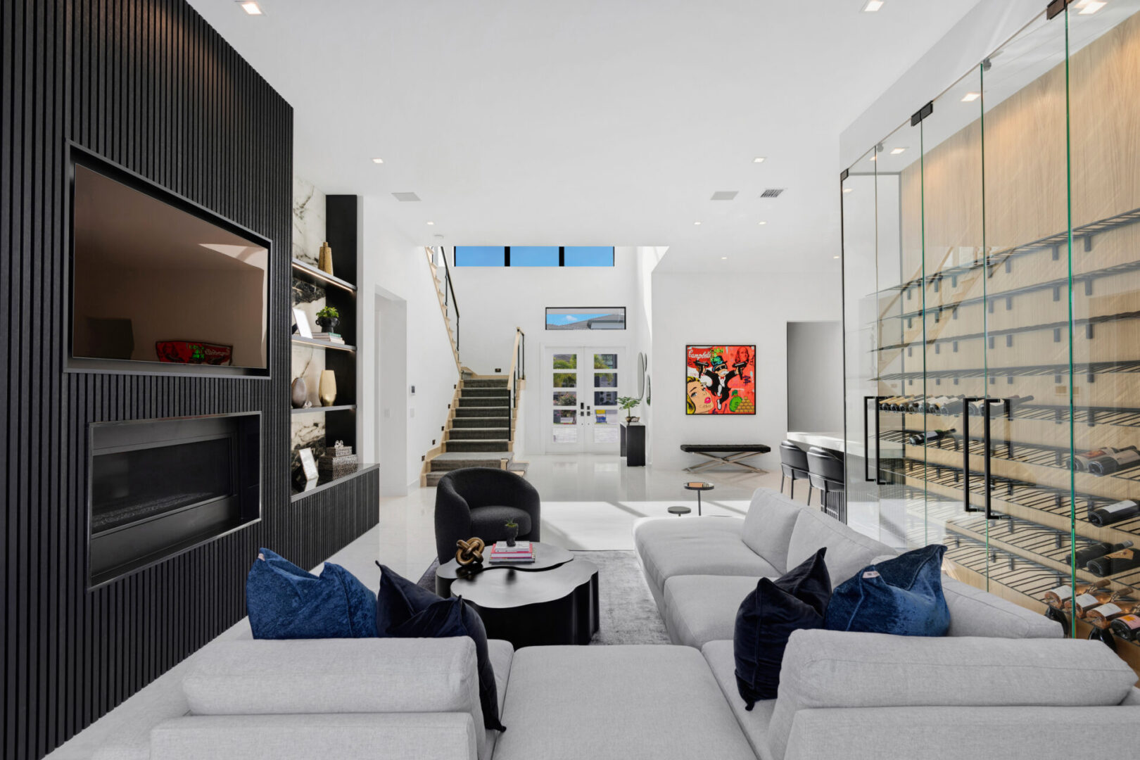 A living room with white furniture and black walls.